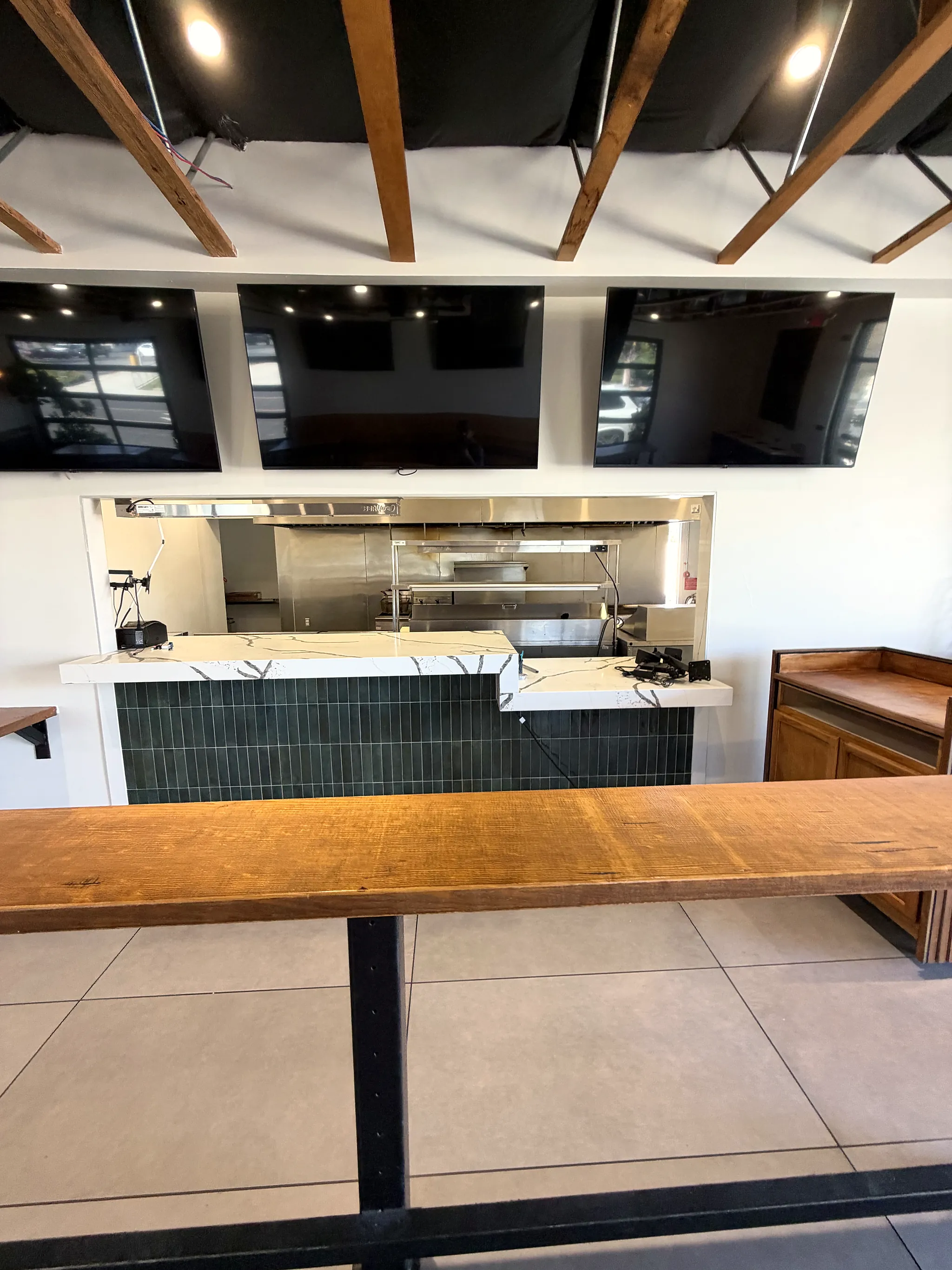 Service counter with green tile and a view into the kitchen