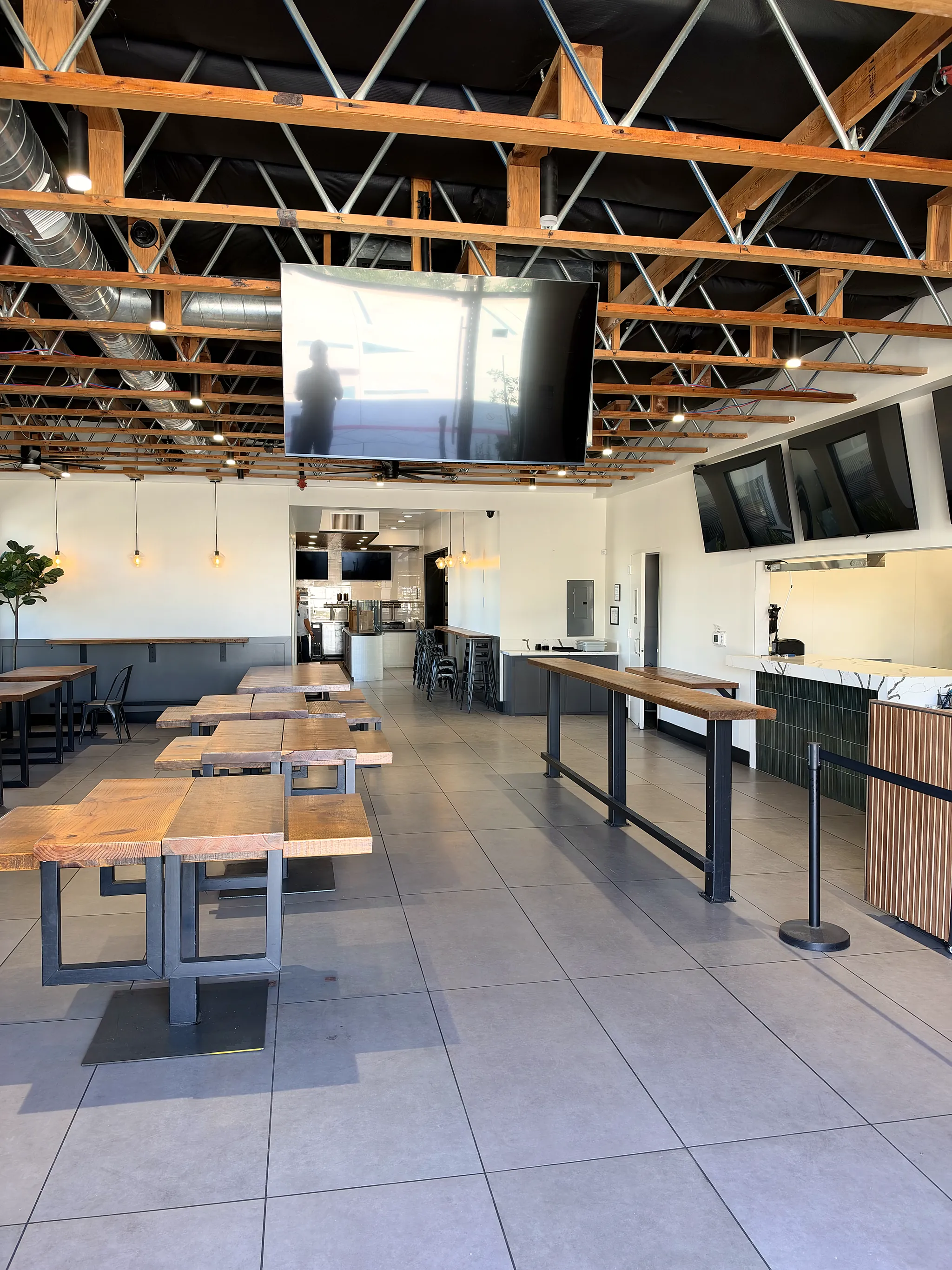 Dining hall with communal tables and a standing bar rail
