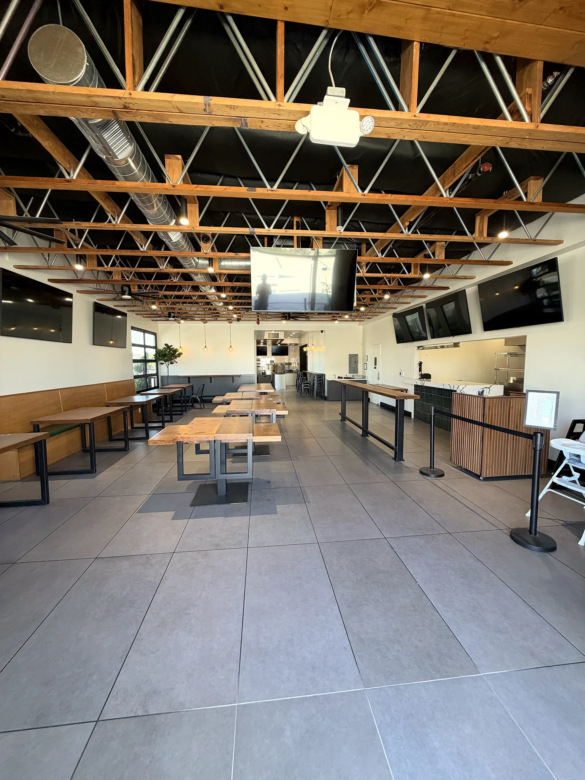 Main dining hall with exposed wood trusses and long communal tables