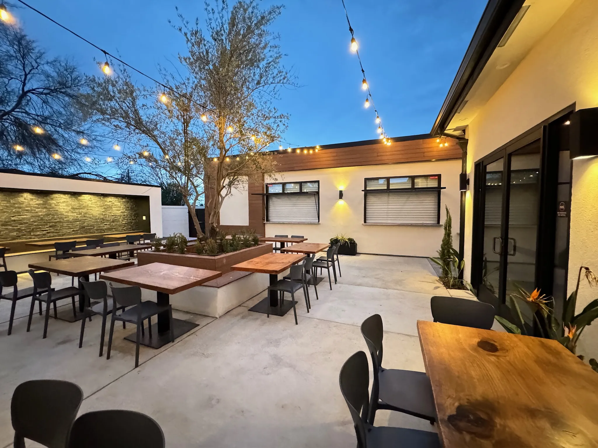 Courtyard tables set for evening under string lights